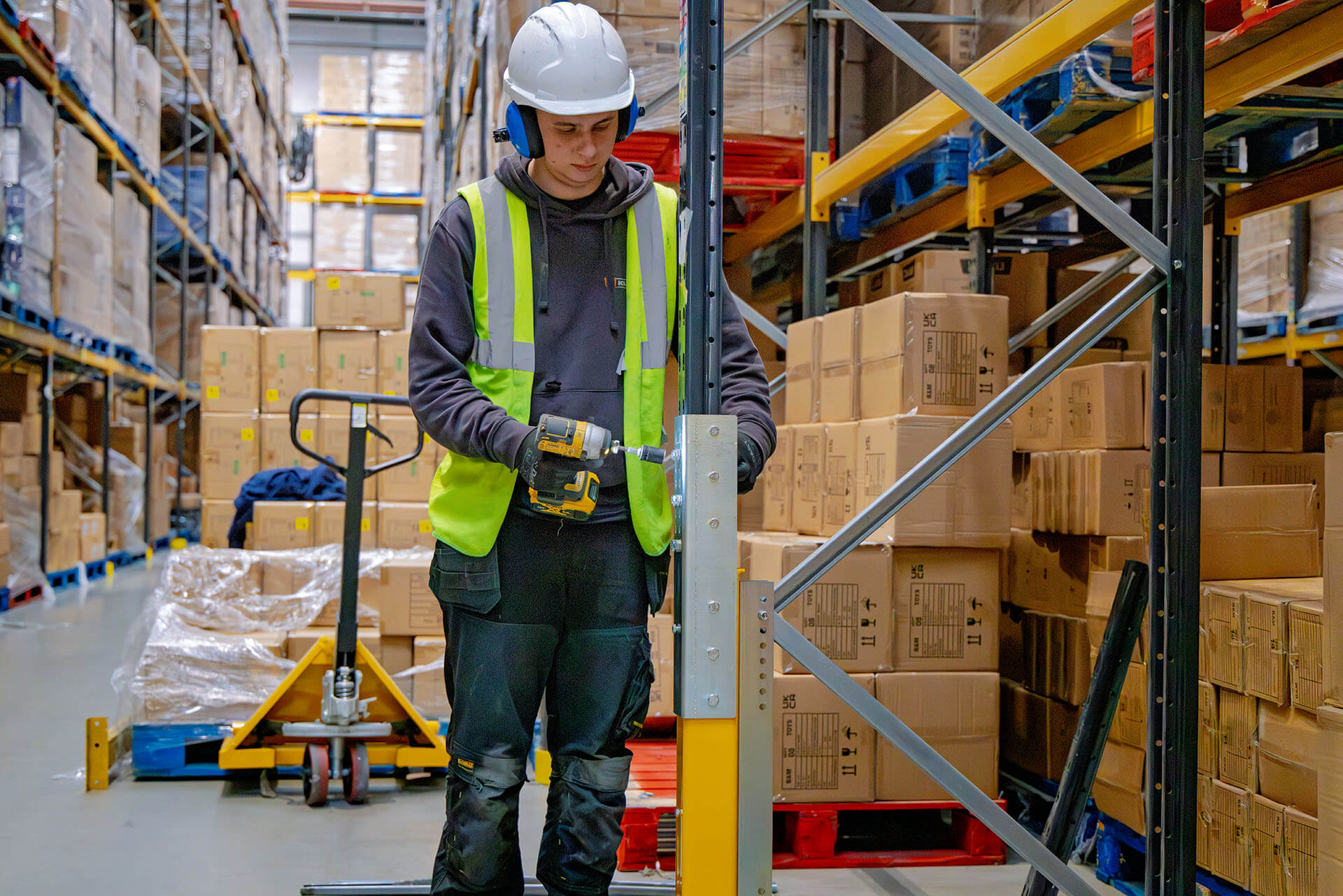 A man installing Goliath onto existing racking
